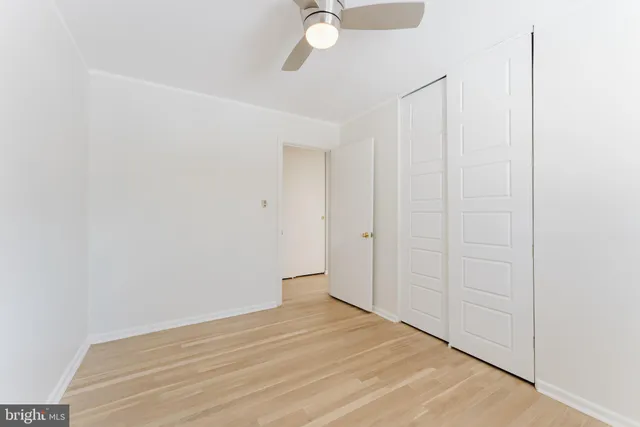 a view of a room with wooden floor and fan