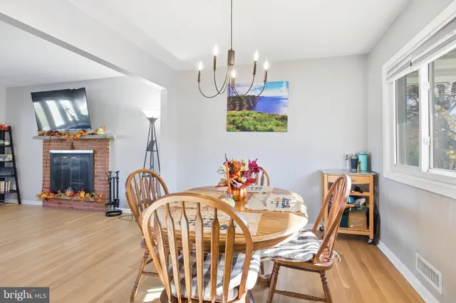 a view of a dining room with furniture a chandelier and wooden floor