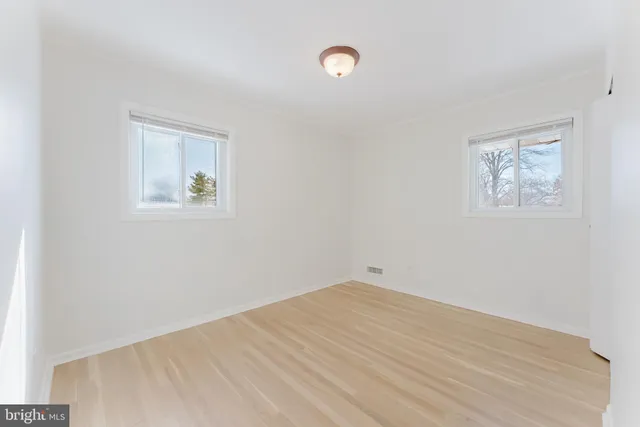 an empty room with a painting and a window