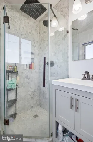 a bathroom with a shower sink and mirror