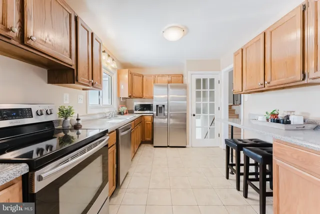 a kitchen with stainless steel appliances a stove a sink cabinets and a window