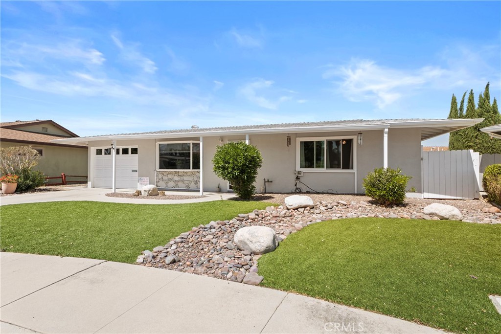 541 Shasta Way Hemet, CA 92543 - Photo 3 of 34 a front view of a house with a garden and plants
