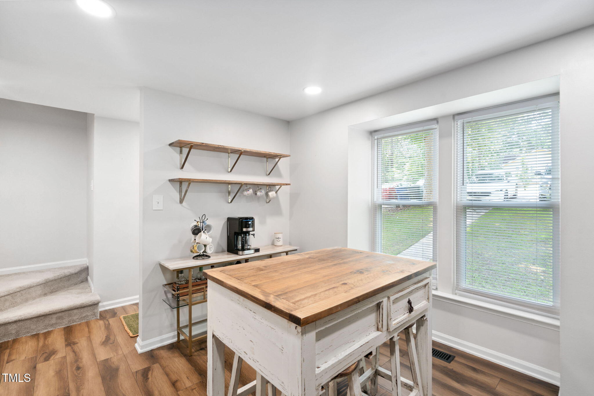 7286 Shellburne Drive Raleigh, NC 27612 - Photo 2 of 36 a kitchen that has a kitchen island wooden floor dining table and a large window