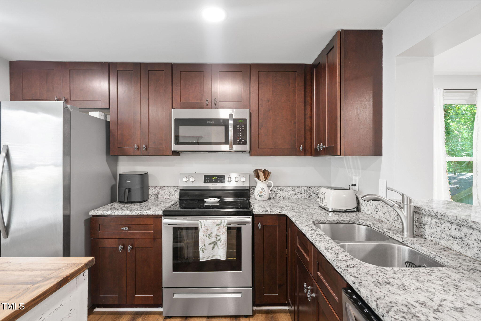 7286 Shellburne Drive Raleigh, NC 27612 - Photo 3 of 36 a kitchen with granite countertop stainless steel appliances sink microwave and refrigerator