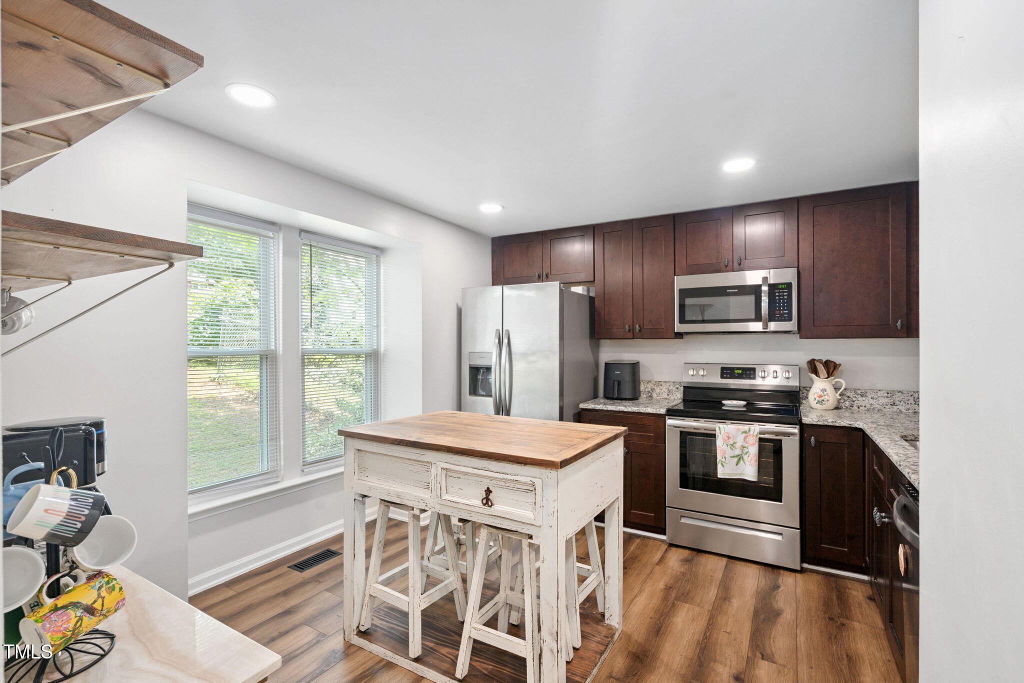 7286 Shellburne Drive Raleigh, NC 27612 - Photo 4 of 36 a kitchen with stainless steel appliances granite countertop a refrigerator a stove top oven a sink dishwasher and white cabinets with wooden floor
