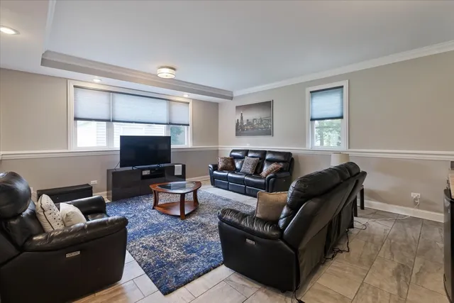 a living room with furniture a flat screen tv and a window