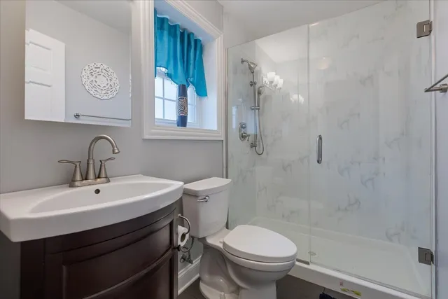 a bathroom with a sink a toilet and a shower