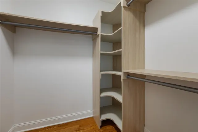 a view of walk in closet with clothes and shoes