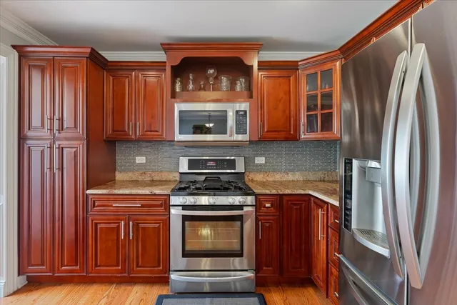 a kitchen with stainless steel appliances granite countertop a stove a refrigerator and a microwave