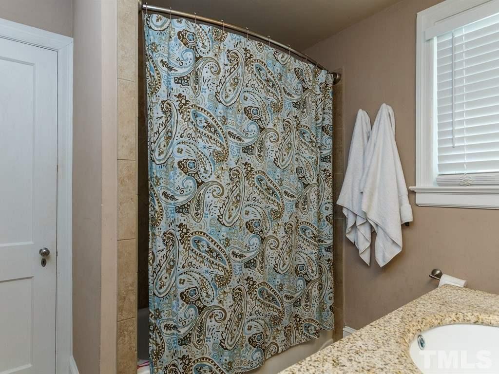 2715 Kilgore Avenue Raleigh, NC 27607 - Photo 14 of 25 a bathroom with a shower curtain and a sink