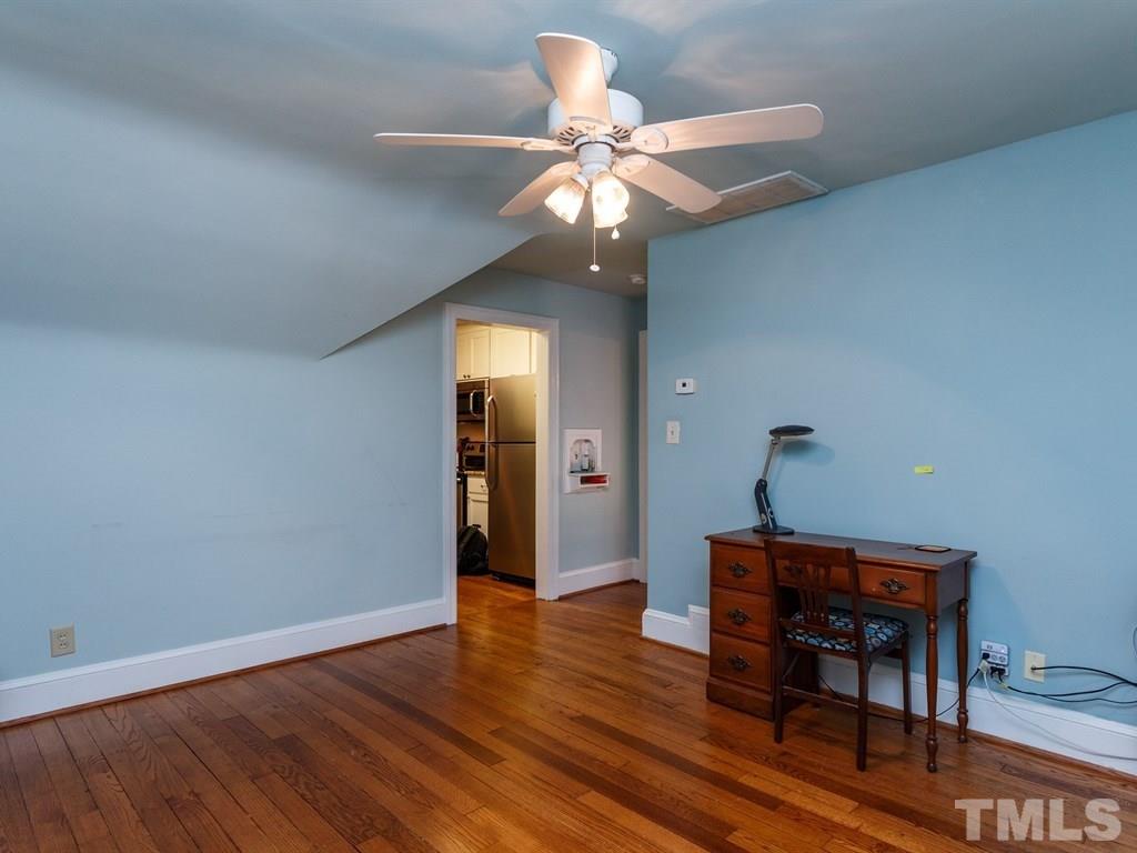 2715 Kilgore Avenue Raleigh, NC 27607 - Photo 10 of 25 a dining room with wooden floor a chandelier a wooden table and chairs