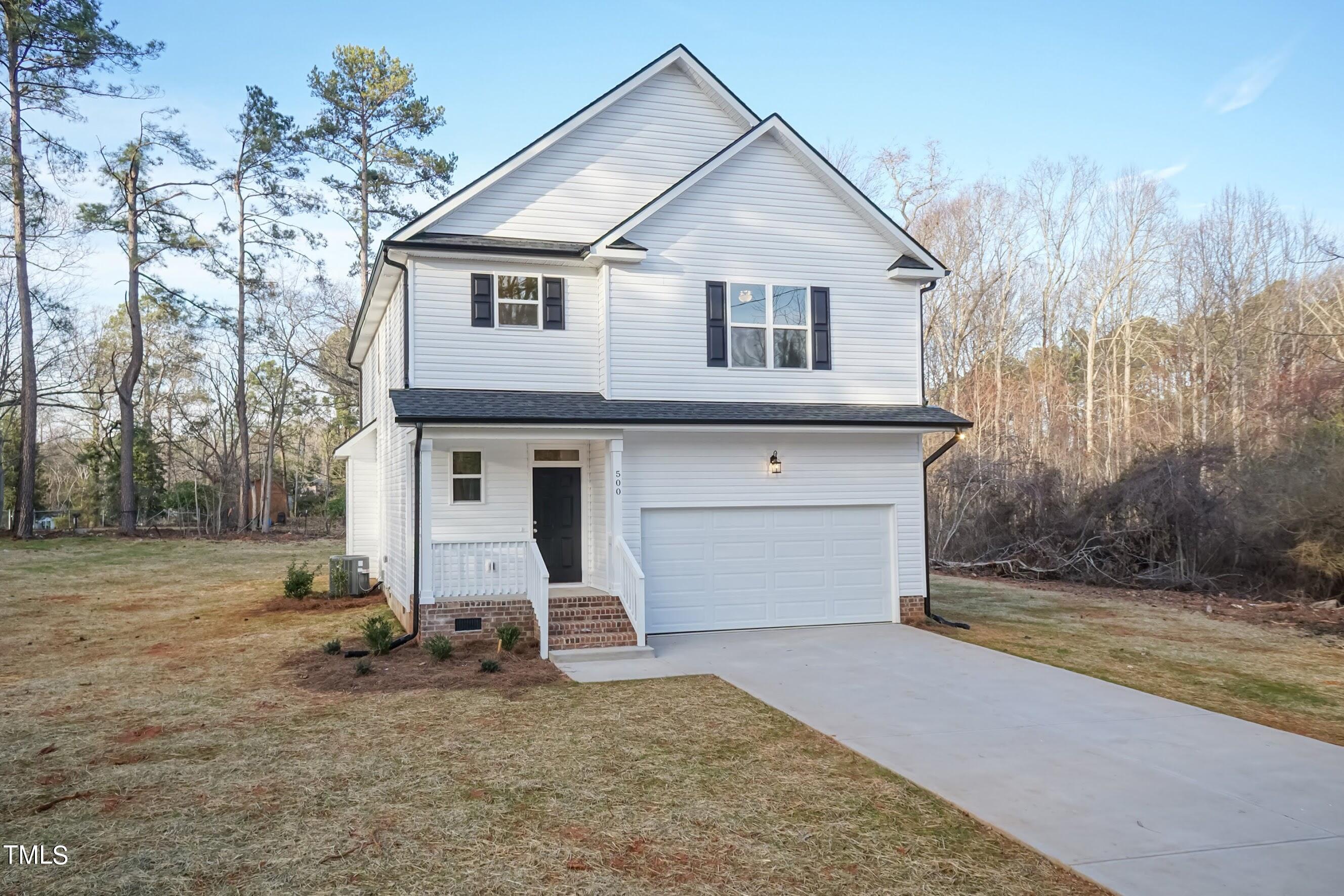 500 Poplar Springs Church Road Raleigh, NC 27603 - Photo 1 of 36 a view of a white house with a large tree and wooden fence
