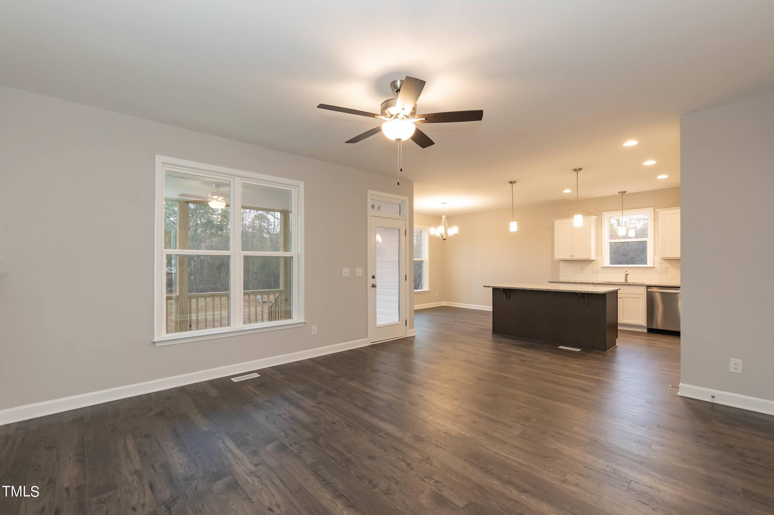 500 Poplar Springs Church Road Raleigh, NC 27603 - Photo 14 of 36 a view of an empty room with a kitchen and wooden floor