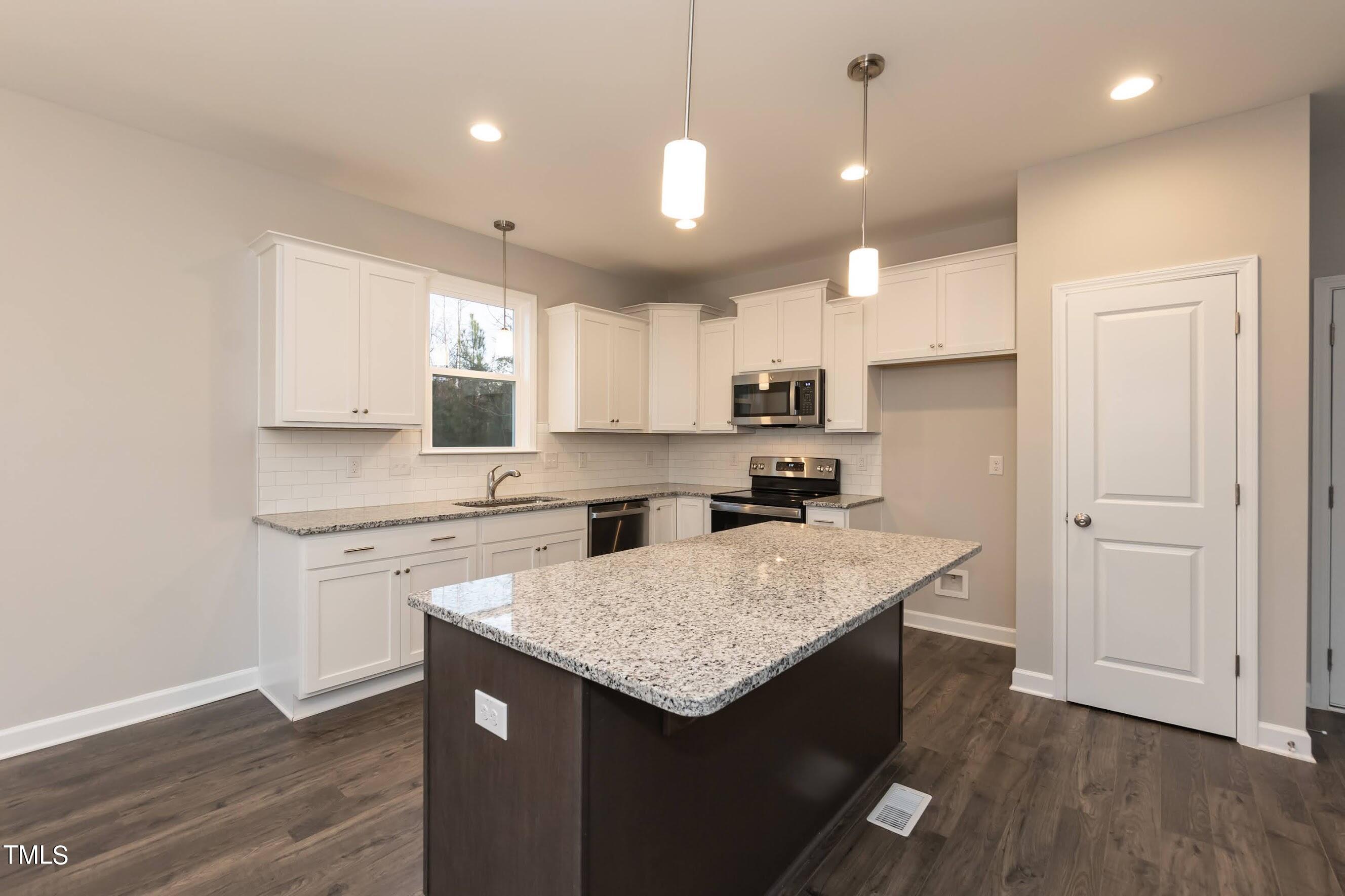 500 Poplar Springs Church Road Raleigh, NC 27603 - Photo 20 of 36 a kitchen with a sink a kitchen island and stainless steel appliances