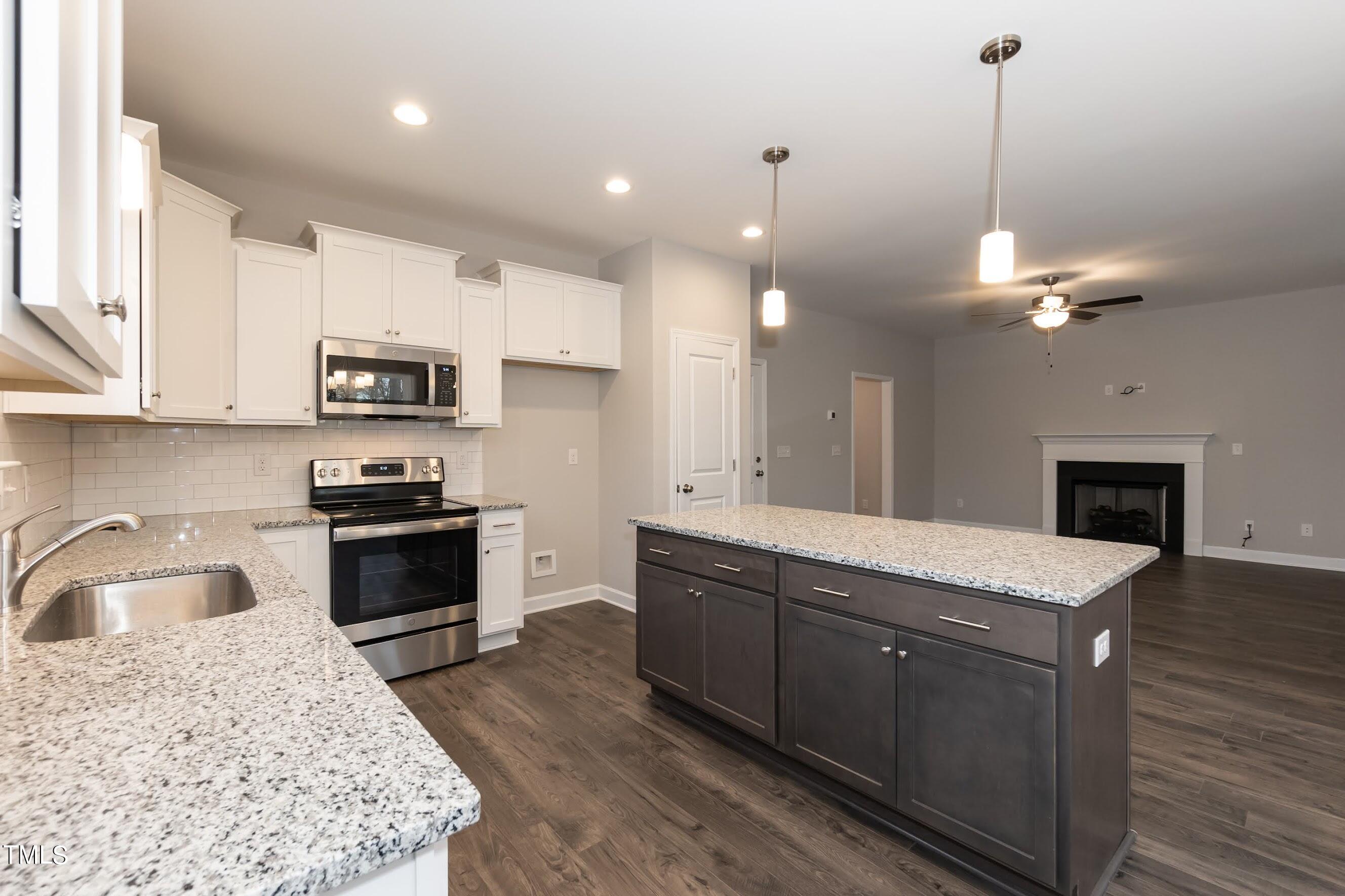 500 Poplar Springs Church Road Raleigh, NC 27603 - Photo 21 of 36 a kitchen with kitchen island granite countertop a sink a counter top space appliances and cabinets