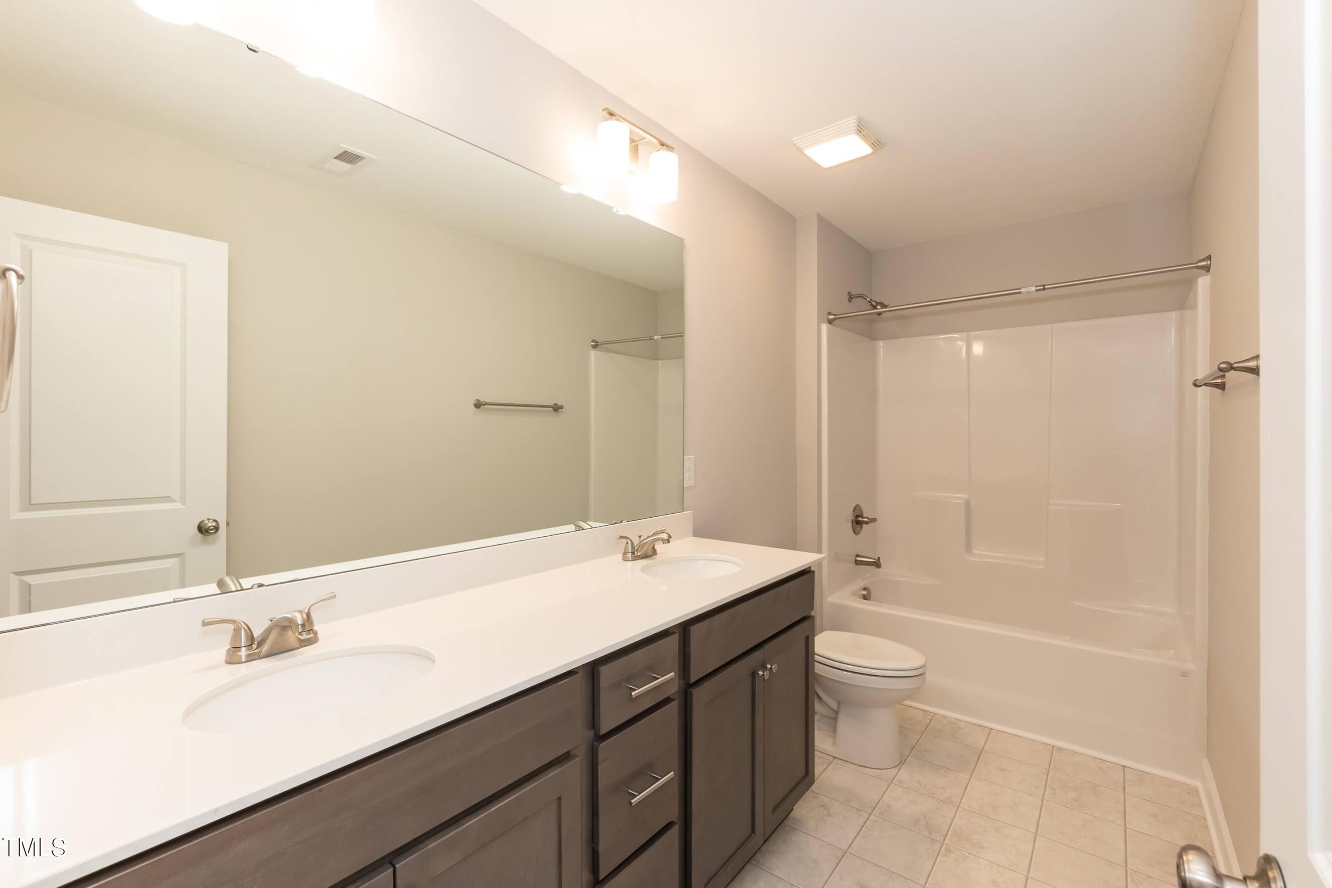 500 Poplar Springs Church Road Raleigh, NC 27603 - Photo 34 of 36 a bathroom with a sink double vanity granite tub shower and a mirror