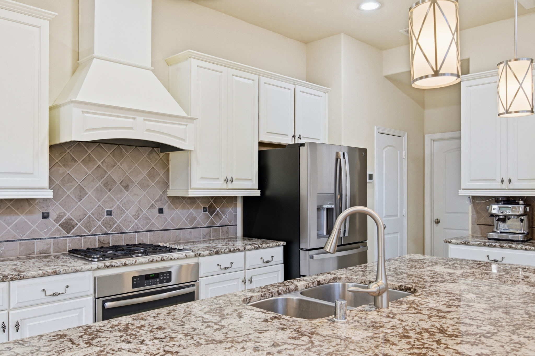 24534 Jenns Creek Court Spring, TX 77389 - Photo 14 of 31 a kitchen with granite countertop a stove a refrigerator and a stove top oven
