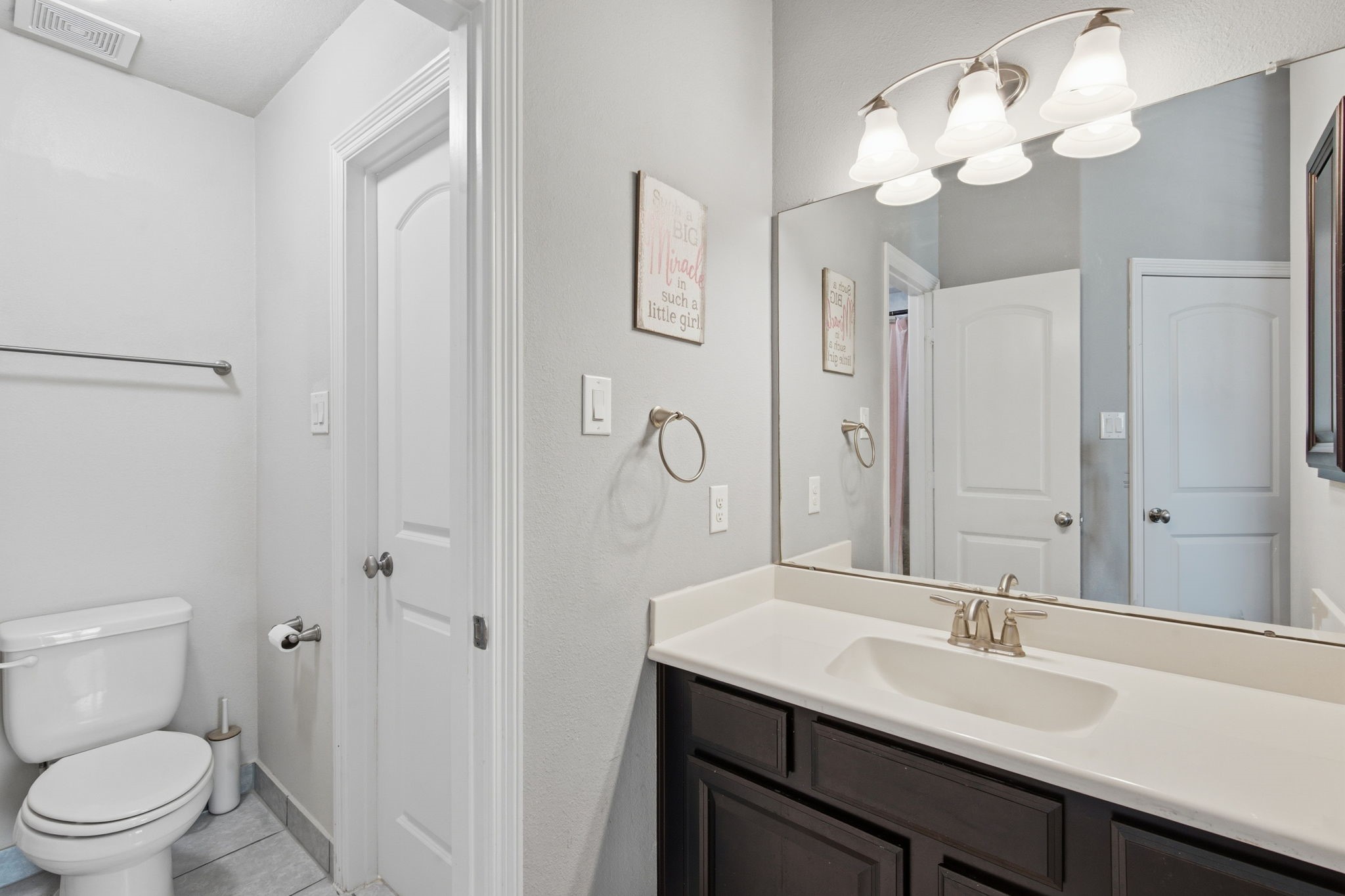 24534 Jenns Creek Court Spring, TX 77389 - Photo 25 of 31 a bathroom with a granite countertop sink a toilet and a mirror