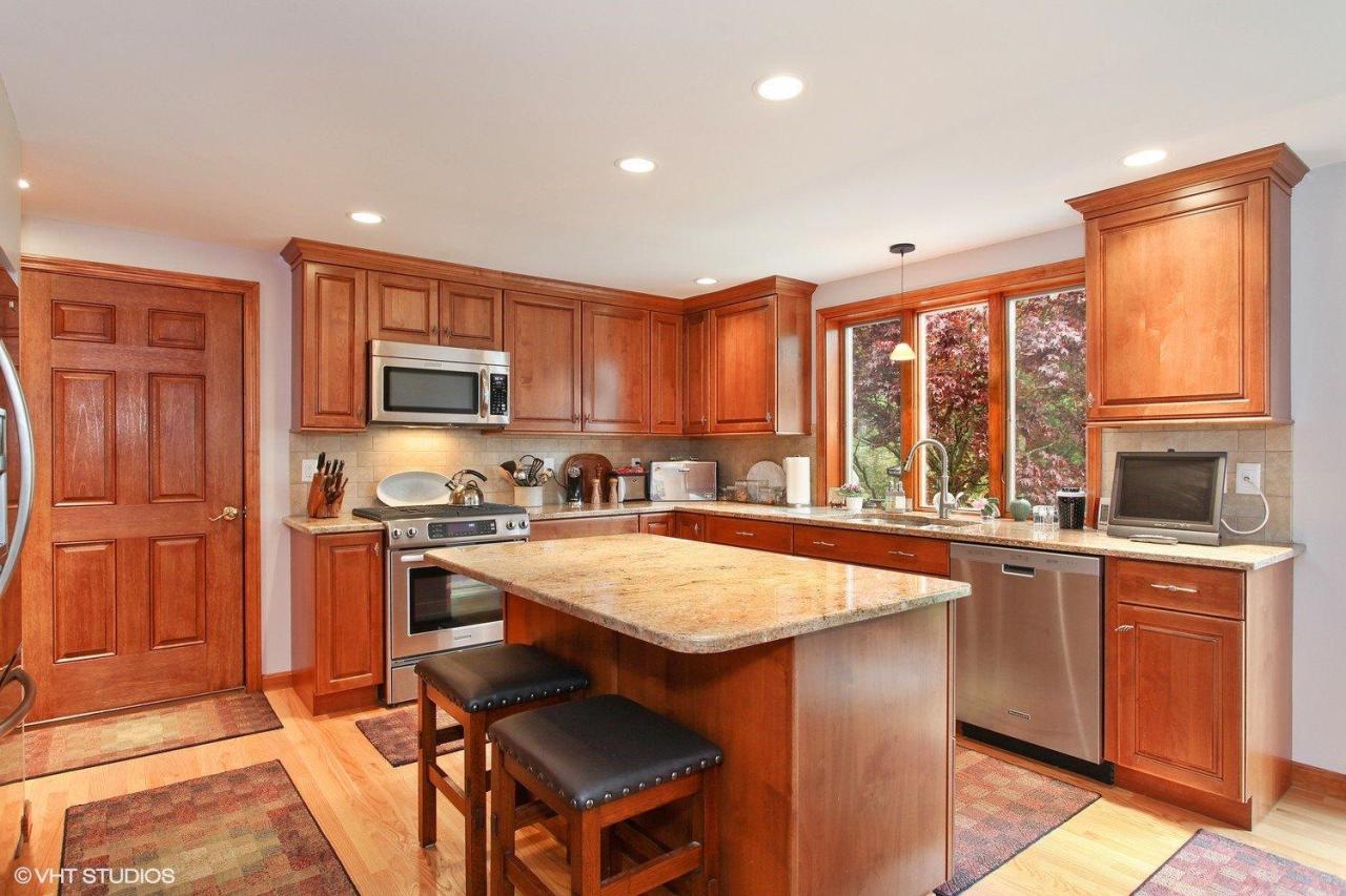 74 Oval Road Chatham, MA 02633 - Photo 3 of 16 a kitchen with stainless steel appliances granite countertop a stove top oven a sink dishwasher a dining table and chairs with wooden floor