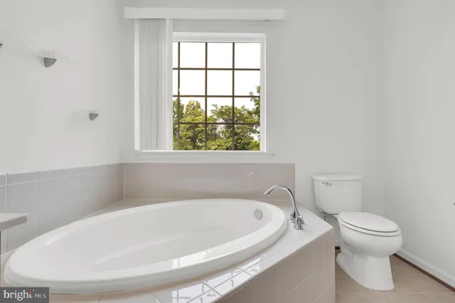 a white bath tub sitting next to a toilet