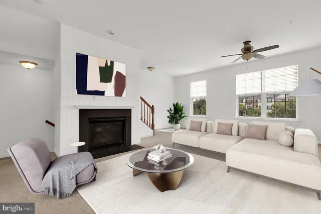 a living room with furniture a fireplace and a large window