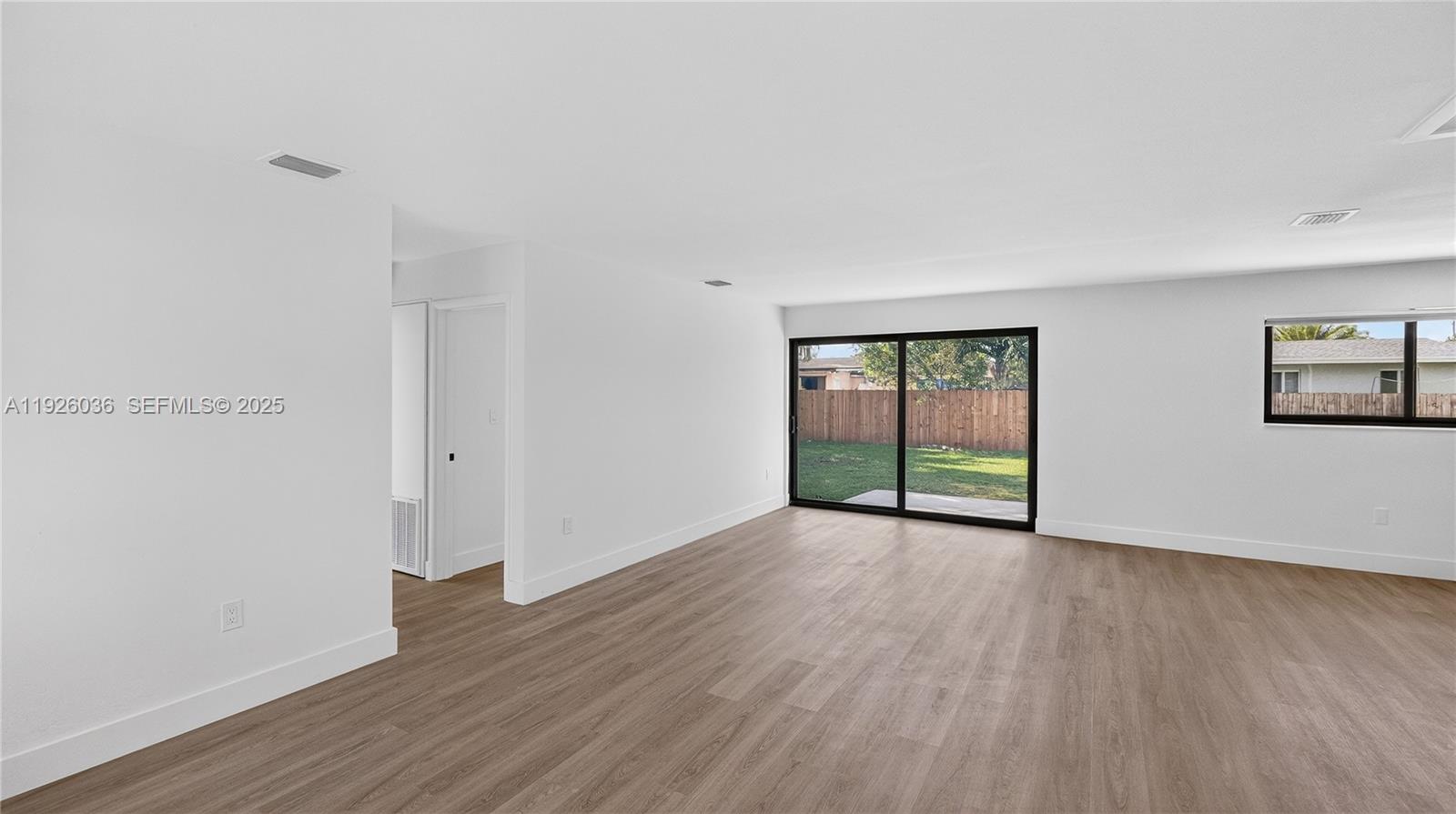 4850 Southwest 93rd Court Miami, FL 33165 - Photo 4 of 25 a view of an empty room with wooden floor and a window