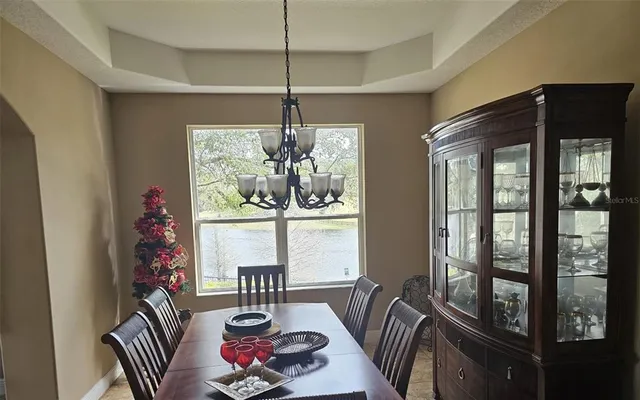 a view of a dining room with furniture a chandelier and window