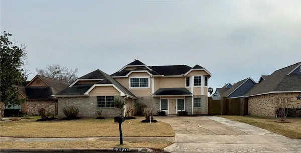 a front view of a house with a garden and yard