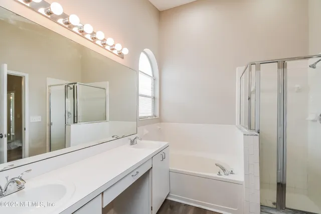 an empty room with wooden floor chandelier fan and windows