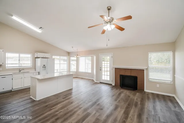a living room with stainless steel appliances granite countertop furniture and a fireplace