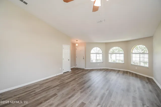wooden floor in an empty room with a window