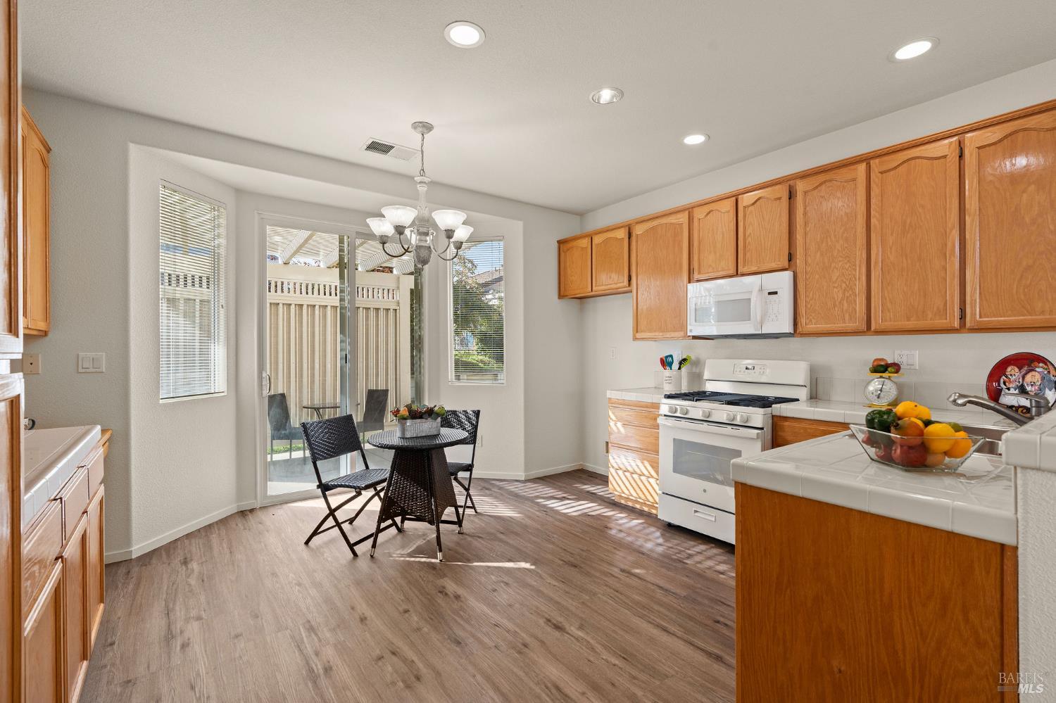 732 Summerset Drive Rio Vista, CA 94571 - Photo 8 of 68 kitchen with new LVP flooring, oak cabinets, tile counters, and new gas range and dishwasher