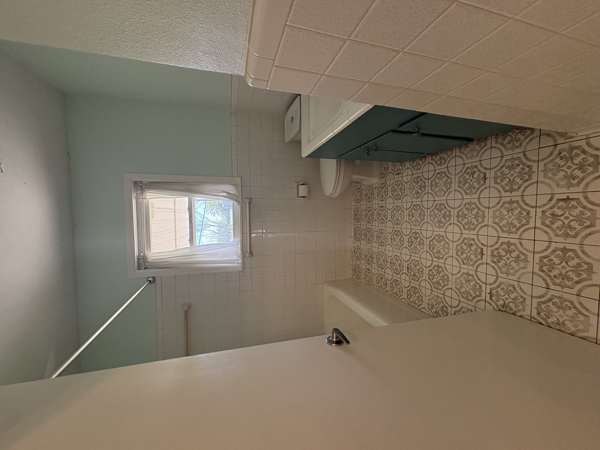 9032 Nuckols Crossing Road Austin, TX 78744 - Photo 9 of 14 A well-maintained bathroom with a patterned tile floor and a window providing natural light.