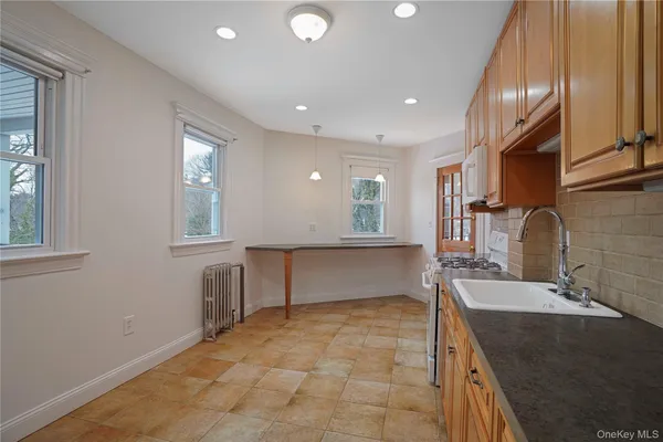 a large kitchen with kitchen island granite countertop a sink and a stove top oven