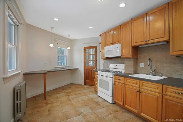 a large kitchen with stainless steel appliances granite countertop a sink and cabinets