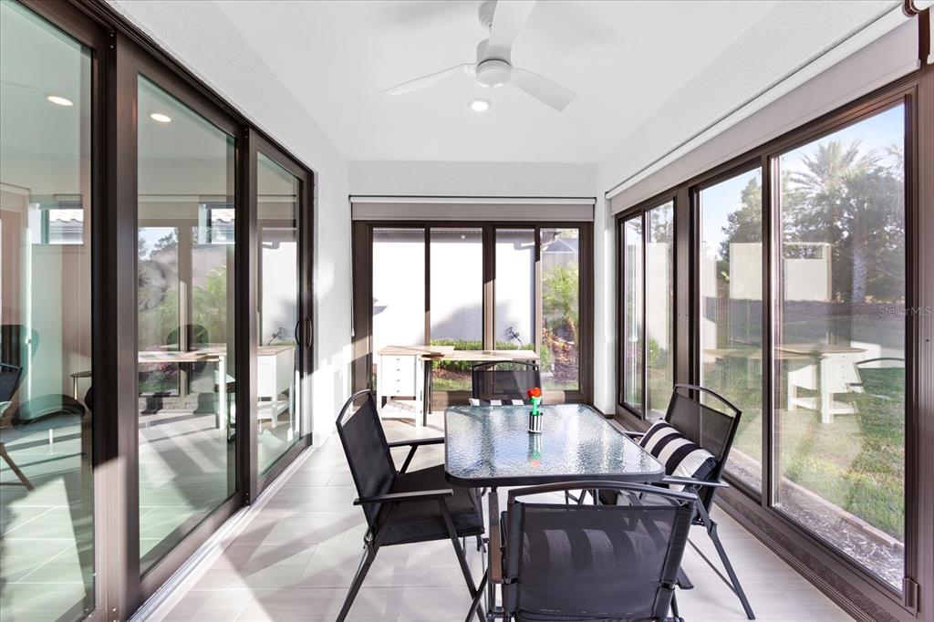6713 Alstead Circle Lakewood Ranch, FL 34202 - Photo 19 of 86 a view of a dining room with furniture large windows and wooden floor