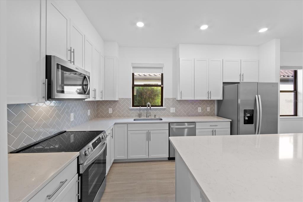 6713 Alstead Circle Lakewood Ranch, FL 34202 - Photo 7 of 86 a kitchen with a sink a stove and refrigerator