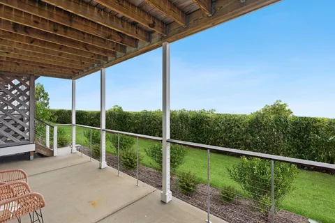a view of a deck with a floor to ceiling window and wooden fence