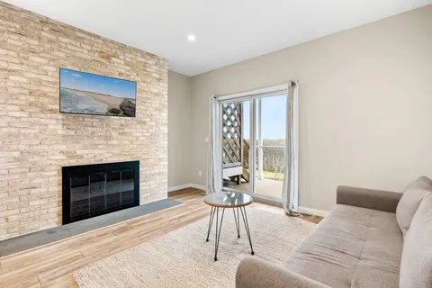 a living room with furniture a flat screen tv and a fireplace