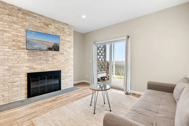 a living room with furniture a flat screen tv and a fireplace
