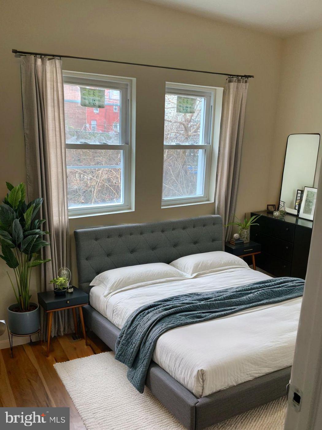 4840 North Camac Street, Unit 1 Philadelphia, PA 19141 - Photo 2 of 8 a bedroom with a bed and a potted plant