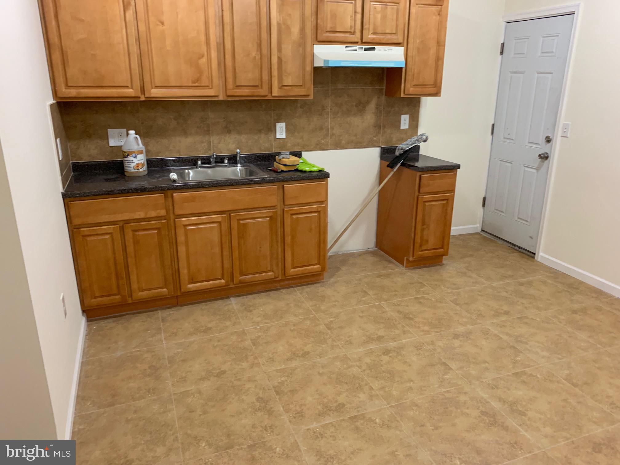 4840 North Camac Street, Unit 1 Philadelphia, PA 19141 - Photo 7 of 8 a kitchen with stainless steel appliances granite countertop a stove a sink and a refrigerator