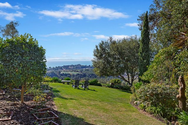 a view of a patio with furniture and a garden
