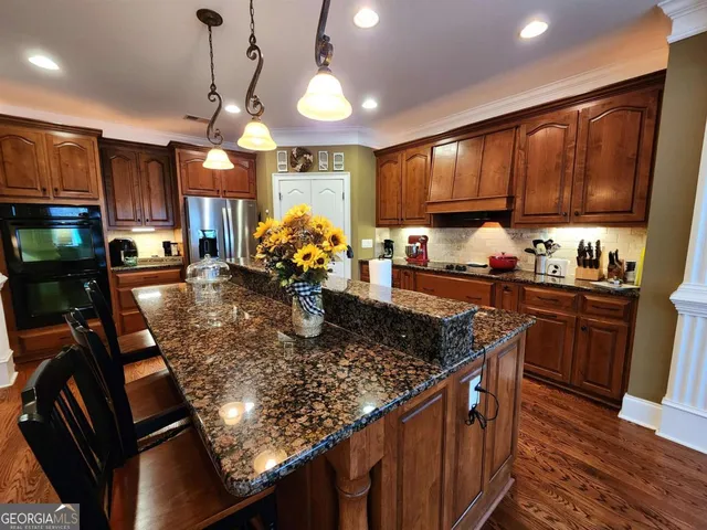 a kitchen with stainless steel appliances granite countertop a sink stove and cabinets