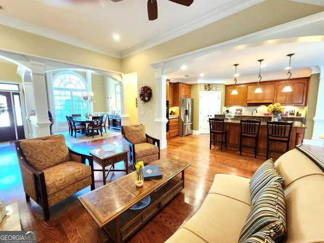 a living room with furniture kitchen view and a large window