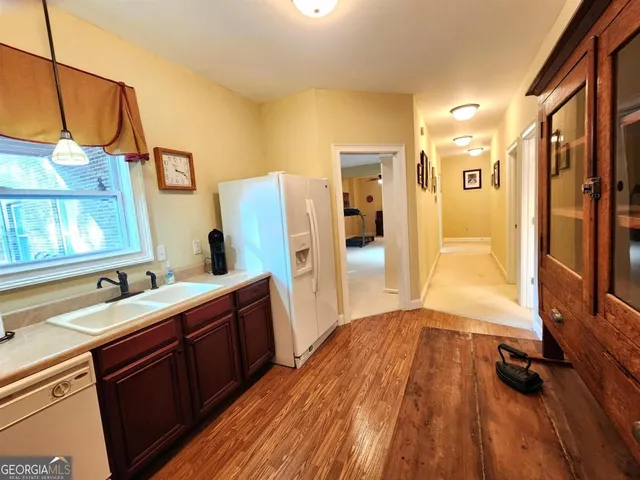 a view of a swimming pool with chairs and table in the garden