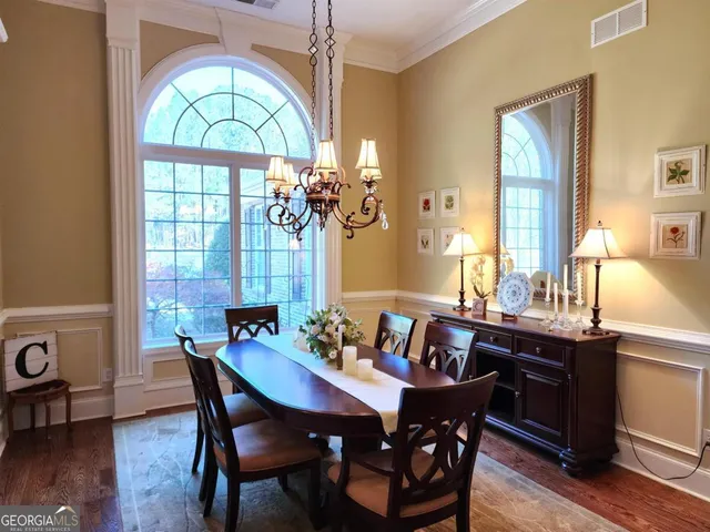 a view of a a dining room with furniture window and wooden floor