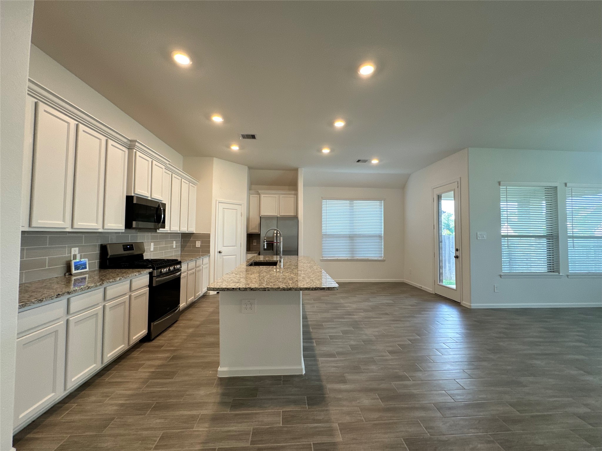 17311 Grand Canyon Road Conroe, TX 77302 - Photo 7 of 28 a large kitchen with stainless steel appliances granite countertop a large counter top and a stove top oven
