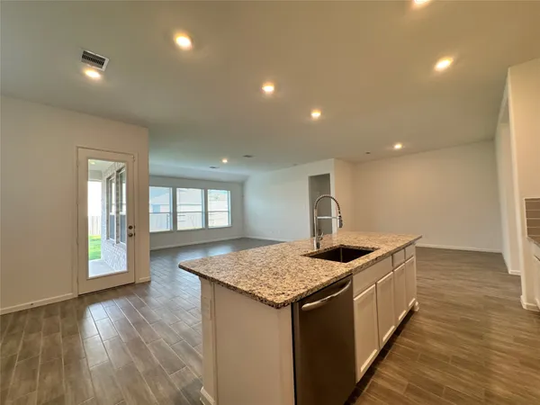 a view of kitchen with granite countertop stainless steel appliances refrigerator and cabinets