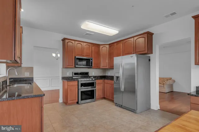a kitchen with stainless steel appliances granite countertop a refrigerator stove and sink